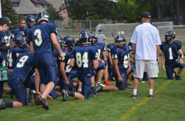 The Boys Varsity Football team prepares to play a game against St. Agnes High School on Sept. 12. The team lost 6-40. "We love big crowds and we love them more when we can hear them,” Senior captain and  offensive lineman Sam Carlson said. 