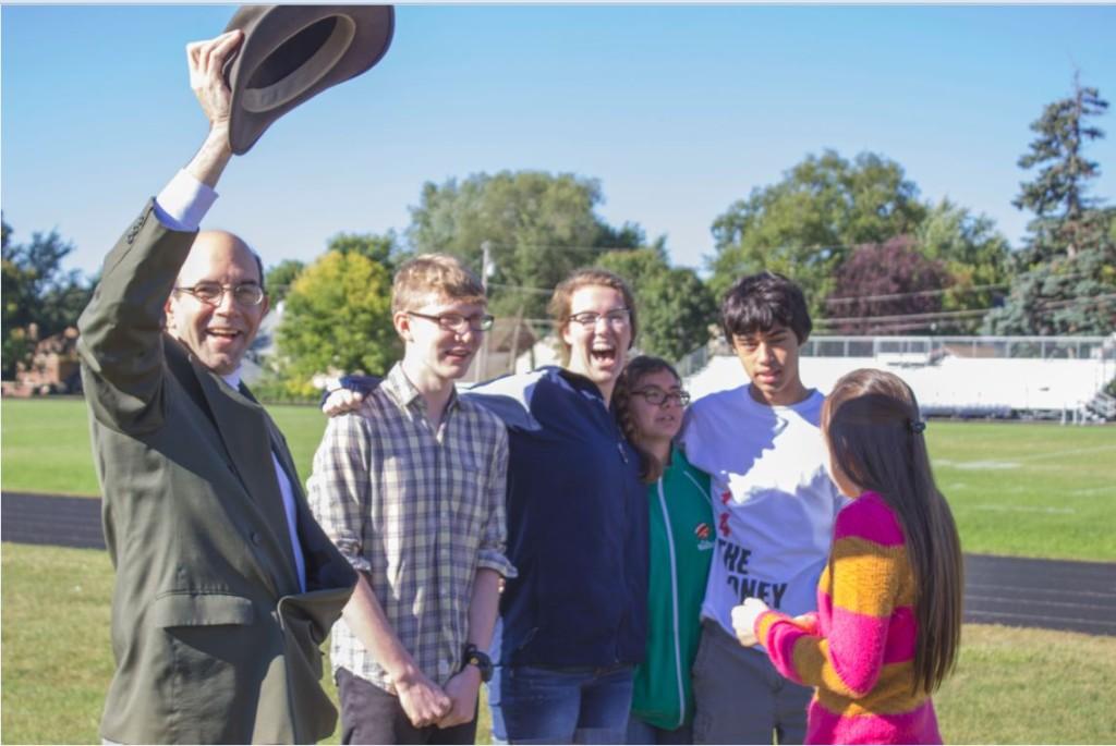 Upper School Science teacher Steve Heilig waves his hat with seniors (L to R) Michael Wlkens, Katherine Jones, Kristen Datta, Steven Go-Rosenberg, and Cristina Zarama to gain the attention of his advisory as students gathered out on the soccer fields during the fire drill.