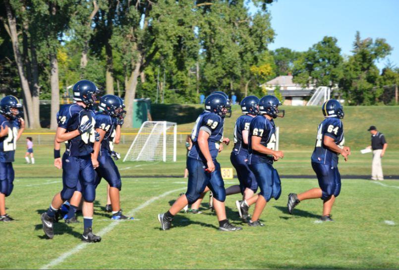 From left to right, senior Andrew Thao, junior Luke Bishop, junior Mychal Morris, sophomore Charlie Ward, Mounds Park Academy junior Billy LeMire, Mounds Park Academy senior Brendan Boyle, and senior Sam Carlson head out onto the field at the start of a game against Spectrum High School on Aug. 30, which the team won 25-22. “I’m extremely confident in our ability to come out and shut down the West Lutheran offense,” senior captain Nick Hoffmann said. 