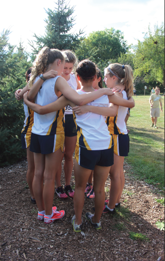 From left: Junior captains Ellen McCarthy and Mary Naas, and eighth grader Val Hart, freshman Neeti
Kulkarni, and eighth grader Greta Sirek visualize before their race at St. Catherine University on Sept. 12. “We lost about four seniors total, who were important contributors to the team, but
we have some really good younger runners who are really growing into the team,” junior
captain Ellen McCarthy said.