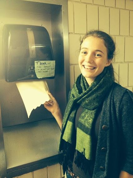 People for Environmental Protection president senior Charlotte Hughes poses with a paper towel dispenser labeled with one of PEP’s signs. “We try to get creative with our projects and announcements, so why not the signs too?” Hughes said.