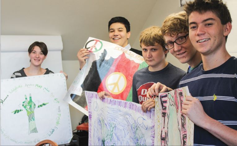 Senior  Modern Asian History students hold their peace flags, which will become part of a virtual quilt of peace in the Global Challenge 20/20.  The students work with students at Covington HS in Virginia and Jiangsu College for International Education in Nanjing, China to solve global problems.   “The three schools look at the issue through different lenses,” US history teacher Sushmita Hodges said. Senior seminar students (L to R): Victoria Guest, Eddy Sharifkhani, Robert Bohjanen, Michael Wilkens, and Marcus Alburez Myers.