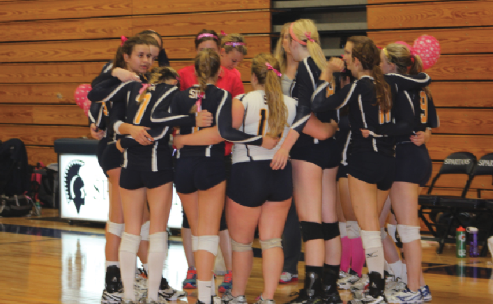 The volleyball team huddles before the Dig Pink game on Oct. 8 against Providence Academy. “We played really well. I think we played together as a team,” senior  defensive specialist Alex Miller said. This was the volleyball program’s second annual Dig Pink night. 
