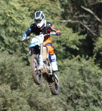 Junior Nicolas Koch performs a jump on a motocross bike. “[A friend] invited me to come try it one day and let me borrow his bike, and I got hooked on it,” Koch said.