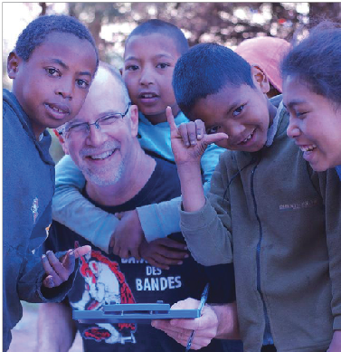 Former Upper School math teacher George Leiter  measures a group of Malagasy children for new TOMS© shoes on Sept. 26. “I’d heard of TOMS ® shoes before,” Leiter said. “But it’d be easy to say ‘we give away shoes,’ and never actually get around to it. It’s nice to know they’re really giving shoes away.”