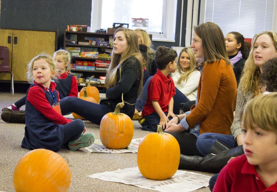 Seniors and kindergartners listen for directions before beginning. This year's pumpkins were slightly larger than previous years'. 