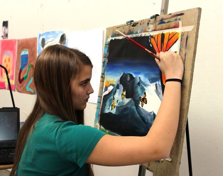 Sophomore Michelle Heilig works on a surrealist painting in the art wing. "I didn’t want to do something weird because all surreal paintings that I have seen have giant eyeballs, and I really didn’t want to do that. So I have giant butterflies instead," Heilig said.