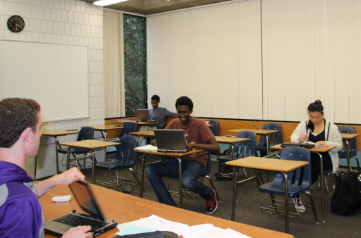 Junior Ben Pettee (front) proctors an after-school detention. “For me, [detention] is a great way to get schoolwork done,” senior Emun Solomon (back left) said. Detentions are assigned as a consequence for latenesses to school and class and can be completed before and after school.