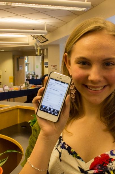 Sophomore Calla Saunders holds up Veracross on her phone. The Upper School Council is working on relaxing the current cell policy. 