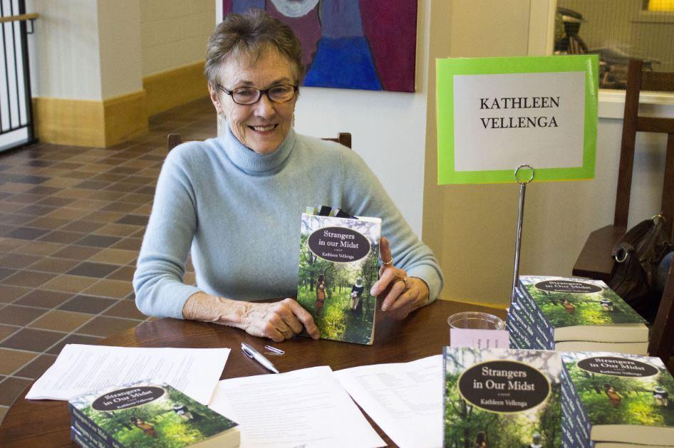 Author Kathleen Vellenga sits at her book signing table in the Summit Center on Nov. 19. Too often in history we know what happens, but in fiction you can make the reader feel it and care about it, she said. 