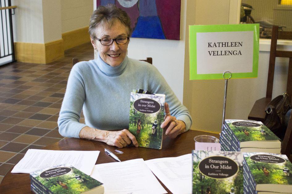 Author Kathleen Vellenga sits at her book signing table in the Summit Center on Nov. 19. "Too often in history we know what happens, but in fiction you can make the reader feel it and care about it," she said. 