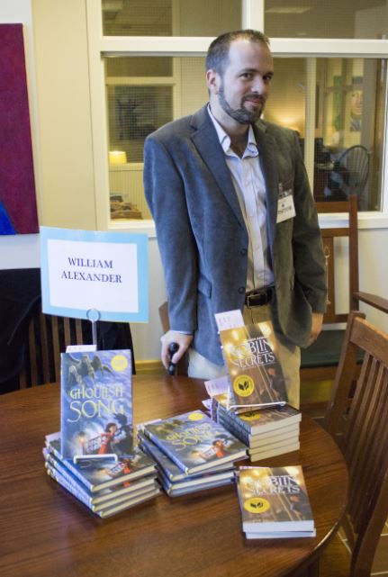 Author+William+Alexander+stands+next+to+his+book+signing+table+on+Nov.+22.+We+all+tell+stories.+Were+all+made+out+of+stories%2C+he+said.+