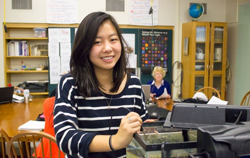 Senior Jessica Wen smiles as she takes the temperature of a zebrafish tank in the Advanced Scientific Research class. “It’s kind of like a college research experience, but it’s in high school,” Wen said. 