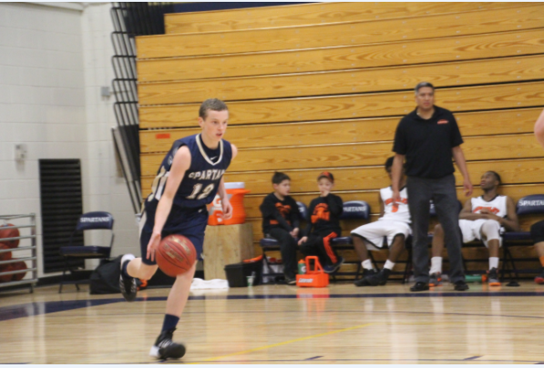 Sophomore Charlie Hooley brings the ball up the court in the team’s Nov. 26 game against St. Paul Humbolt High School. The Spartans beat the Hawks 83-58. 