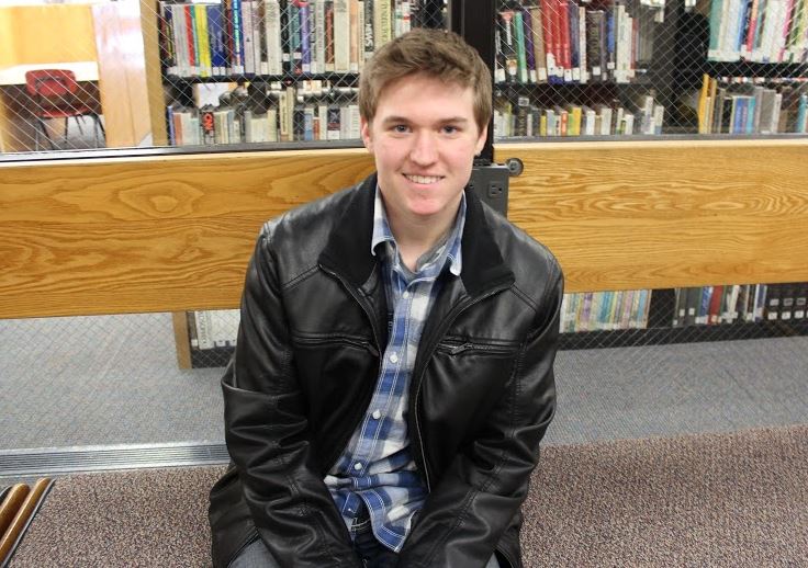 Junior Andrew Chuinard wears a plaid shirt with a black leather jacket. 