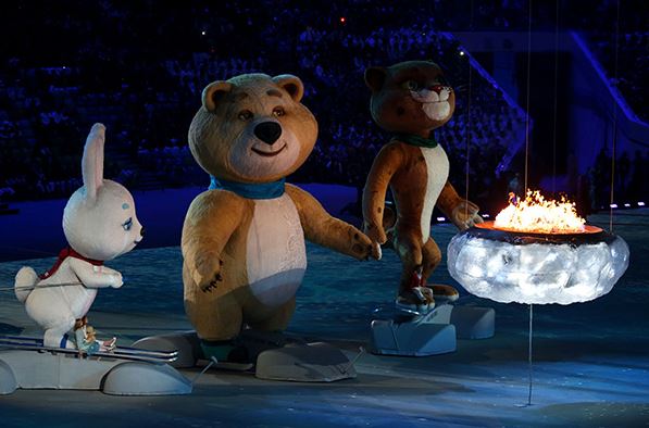 The mascots of the 2014 Winter Olympics arrive on stage to blow out the Olympic flame.