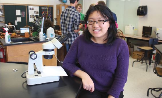 Li poses in her science classroom. “I was looking for the most environmentally friendly way of doing things. Making biofuels from switchgrass is actually carbon negative, and since everything around us is so carbon positive, it’s good to have something which can help mitigate the effects of climate change,” Li said. 