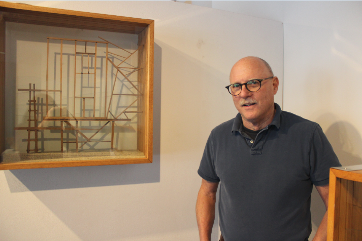 Upper+School+Fine+Arts+teacher+Bob+Jewett+stands+by+his+artwork+in+his+show+at+Drake+Gallery.+%E2%80%9CI+think+working+clay+is+so+much+fun%2C+that+it%E2%80%99d+be+hard+for+someone+to+not+experience+that+kind+of+satisfaction+and+joy+of+pulling+the+clay%2C%E2%80%9D+Jewett+said.+
