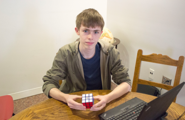 Sophomore Joel Tibbetts holds his completed Rubik’s Cube. Tibbetts saw Rubik’s cube gain popularity around the later years of Middle School. “They’re fun to do over and over because you get a different challenge every time,“ Tibbetts said.