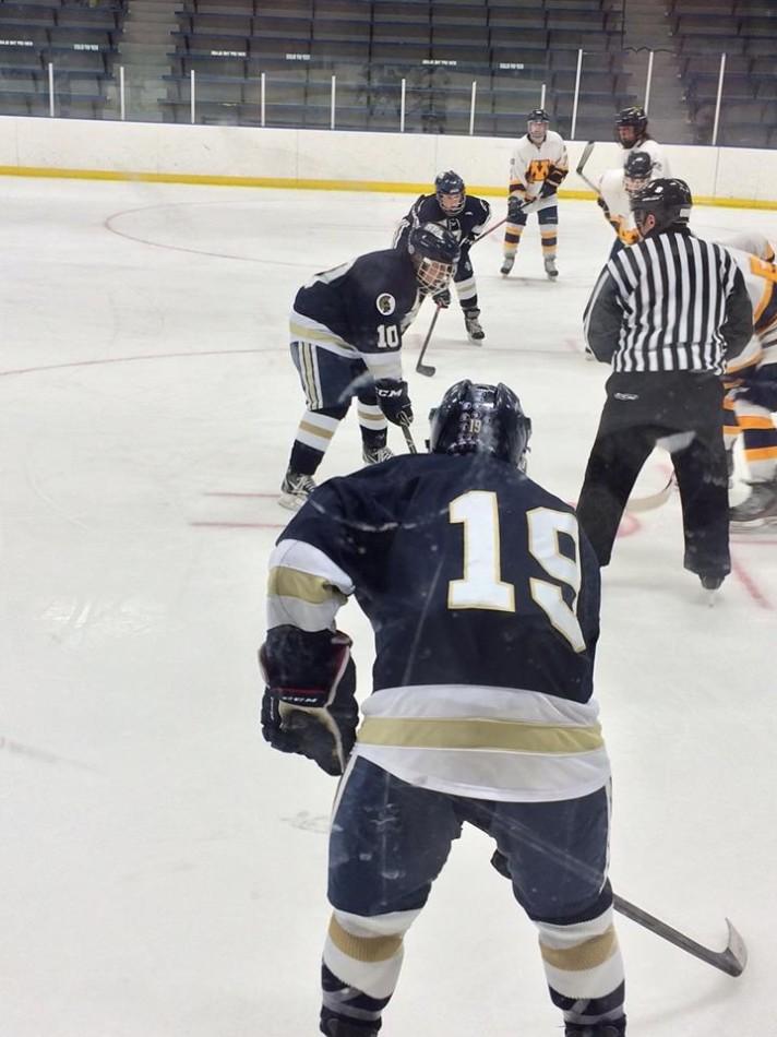 Senior forward Jake Westfield (front) and freshmen forward Riley Bowman (middle) wait for the puck during the game. “When there’s a possibility that our season could be over, everyone is motivated to play harder,” junior Tyler Seplak said.