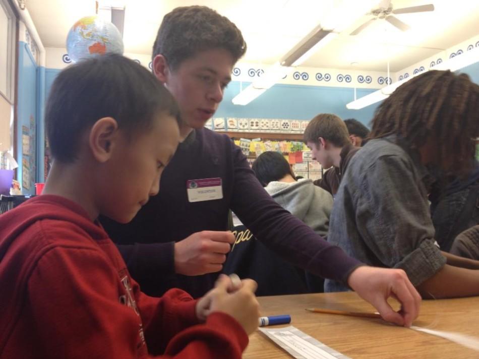 Senior Charlie Rosenblum helps his second grade friend make a name tag. 