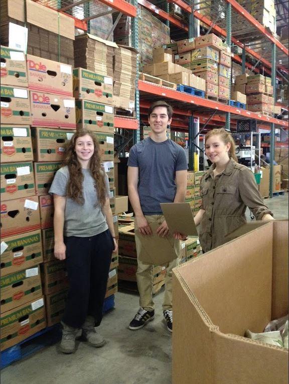 Sophomores Ella Hommeyer, Lukas Kelsey-Friedemann, and Liza Bukingolts stands next to a pallet of boxes of tortillas they packed during their service trip to Second Harvest Heartland. “I think it’s fun because I did tortilla packing last time I was here,” Bukingolts said.