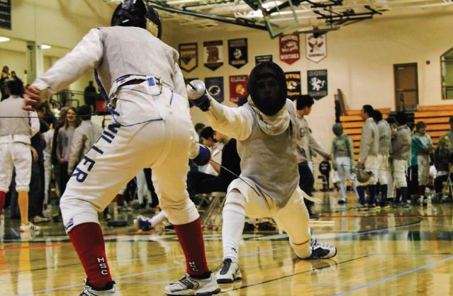 Sophomore foilist Milo Wittenberg lunges at his Minnesota Sword Club opponent at the state fencing competition on Feb. 22 at Holy Family Catholic High School. “We have a very good fencing team, especially when you consider the fact that it’s so young and new to the sport,” women’s epée team captain Katherine Jones said. 