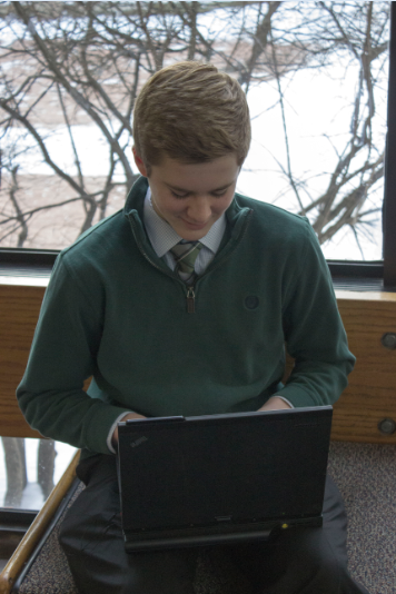 Sophomore Cullen McCabe plays Tetris in the gym foyer. “It’s pretty simple, there’s not a lot of keys that you have to hit,” McCabe said. “The more you play it, the faster you can go… You always want to get a higher score.” The game was originally released in 1984 and is often highly ranked on lists of best games.