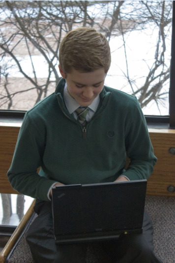 Sophomore Cullen McCabe plays Tetris in the gym foyer. “It’s pretty simple, there’s not a lot of keys that you have to hit,” McCabe said. “The more you play it, the faster you can go… You always want to get a higher score.” The game was originally released in 1984 and is often highly ranked on lists of best games.
