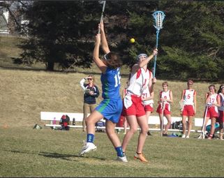 Freshman Mari Knudson fights for the ball during the first Junior Varsity lacrosse game of the season against Eagan on April 11. Everyones up for everything were doing in practice, freshman lacrosse player Ella Matticks said.  Everyones giving it the best theyve got. JV started the season 2-0 and Varsity 1-1. 