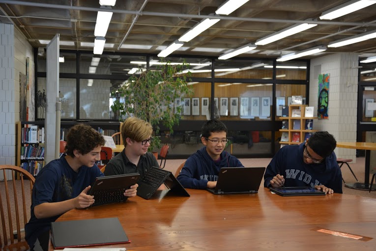 Caption: Freshmen Ben Konstan, Tucker Waltenbaugh, Larry Chen, and Adnan Askari spend their tutorial finishing up work on their new Lenovo Thinkpad Yoga laptops. “The keyboard gets sucked in and the buttons don’t work anymore so when you swivel you aren’t accidentally typing,” Chen explains, citing the new computer’s most distinctive feature. 