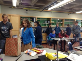 A wave of new freshmen gather for a Science Alliance meeting as seniors Eva Perez-Greene and Jonathon Trevathan prepare for candy-building game. 