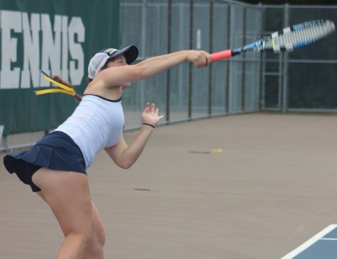 Junior Ella Hommeyer follows through with her serve against Central High School on Sep. 14. 