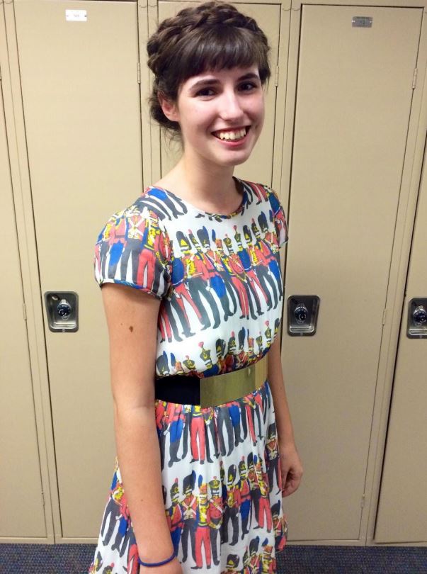 Junior Caroline Montague styles a metallic gold belt with a printed dress and crown braid hairstyle.