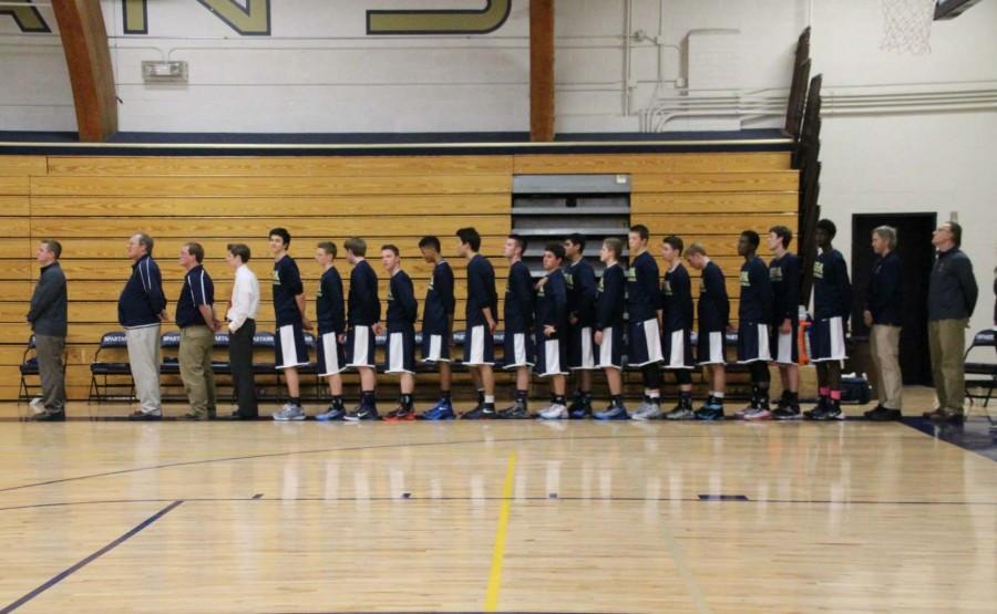 The Spartan Varsity Boys and their coaches stand for The National Anthem.