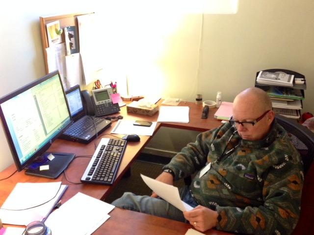 Interim College Counselor John Powell works at his temporary desk in the college counseling office until College Counselor Karna Humphrey returns from maternity leave. “I’ve really been impressed with everything I’ve seen from students to faculty,” Powell said. 