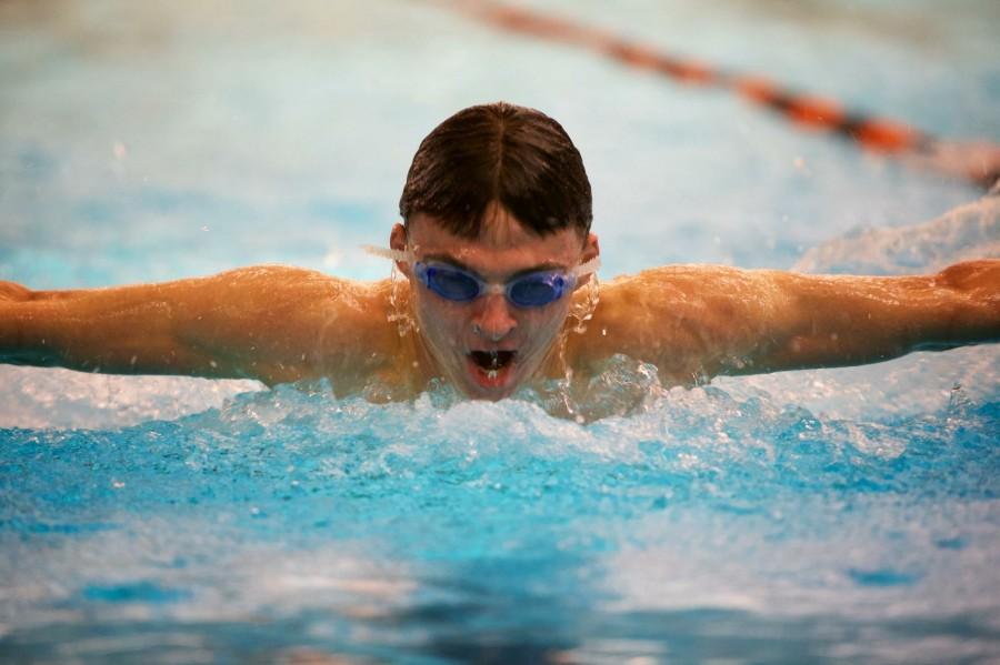 Junior Karsten Runquist swims the butterfly during a meet in the 2013-2014 season. “There’s a lot of teasing and making fun of but By the end of every season its like a big family, which is more important than anything to us,” Runquist said. 