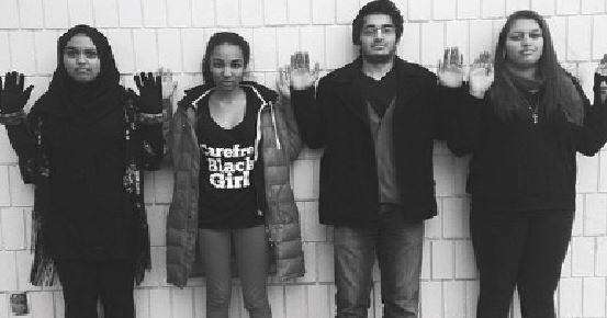 standing in solidarity with Ferguson, seniors Aliza Rahman, Mansuda Arora, Asad Masood, and Alexis Irish raise their hands to sybolize the common rally cry “ Hands up, don’t shoot.”