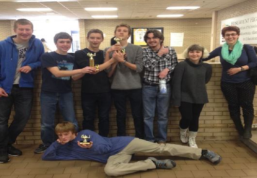 Member of the Quiz bowl team pose with their trophies at the Rosemount Annual Thumb-Racing Academic Competition Event after qualifying for nationals. Left to right: freshman Peter Blanchfield, sophomore Jack Indritz, freshman Jack Hermann, sophomores Ewan Lang, Cole Thompson, and Phoebe Pannier, junior Netta Kaplan, and sophomore Cole Staples (on ground). 