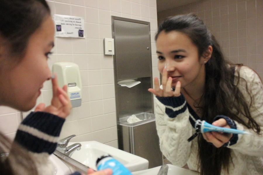 Sophomore Oona Prozinski applies a face mask. [Foundation] really, truly makes it worse. The product gathers in any cracks in the skin and around loose flakes, Prozinski said.