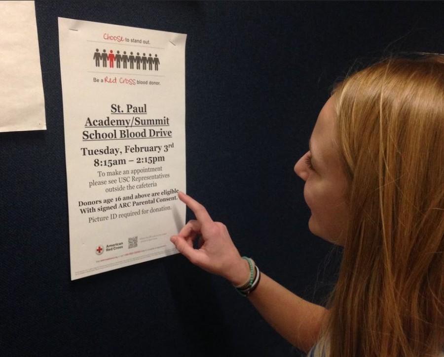 Sophomore Ella Matticks checks out a Blood Drive poster in the athletic hallway, one of many posters posted around school. “I think [the Blood Drive] is a great thing our school does,” Matticks said. 