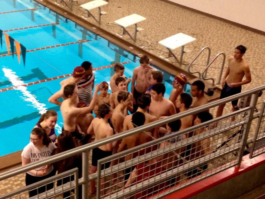 The boys' team gathers to cheer at the end of the meet.