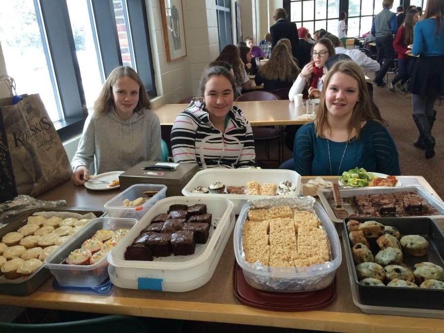 Sophomores+Mackenzie+Kuller%2C+Shelby+Tietel%2C+and+Samantha+Bluhm+work+at+the+bake+sale+to+raise+funds+for+Heifer+International+during+their+lunch+period.+