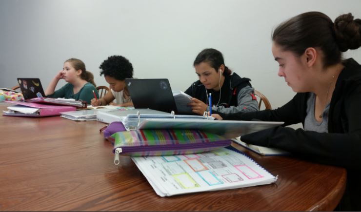 Freshmen Anna Commers, Noa Carlson, Lauren Datta, and Eva Garcia do homework during period 3 study hall. “I’m really fine with it. study halls help me to manage my time better and get stuff done,” freshman Jasper Salverda said.