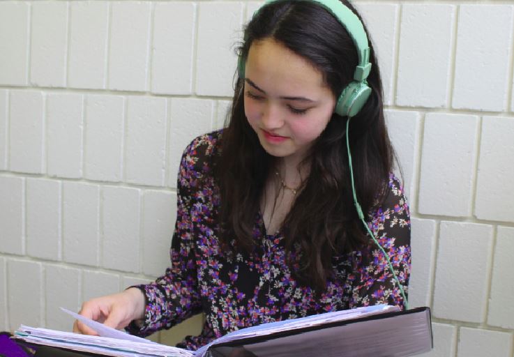 Freshman Maya Shrestha listens to music while studying in the gym foyer. “Having some background noise helps me focus on my work,” she said.