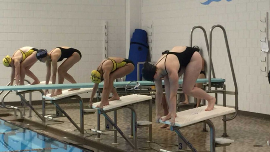 SPARKS SWIM AND DIVE take position on the starting block before entering the pool for a race. “There are nine teams in our division and we normally place 4th, but this year I think we can place 3rd,” senior Maya Smith said.