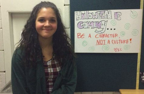 Intercultural Club co-president Hana Martinez stands besides one of their posters warning against cultural appropriation around the school. 
