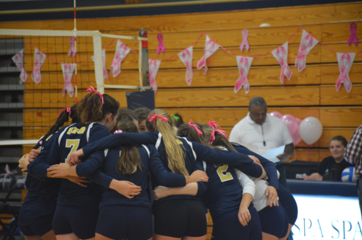 Varsity Volleyball gathers on the court following a rally
