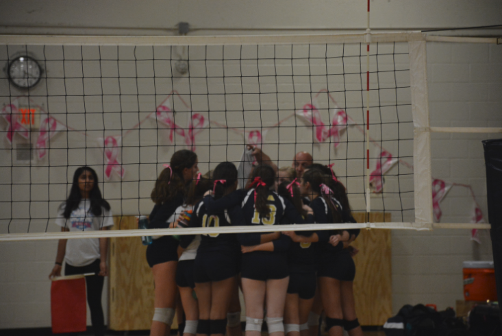 The Spartans Varsity Volleyball team huddles up to discuss strategy midway through the section match against Providence Academy