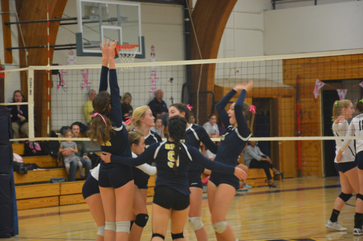 Freshman Blythe Rients leaps above the net in attempt to spike the ball